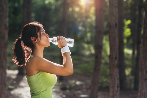 woman drinking water while outdoors